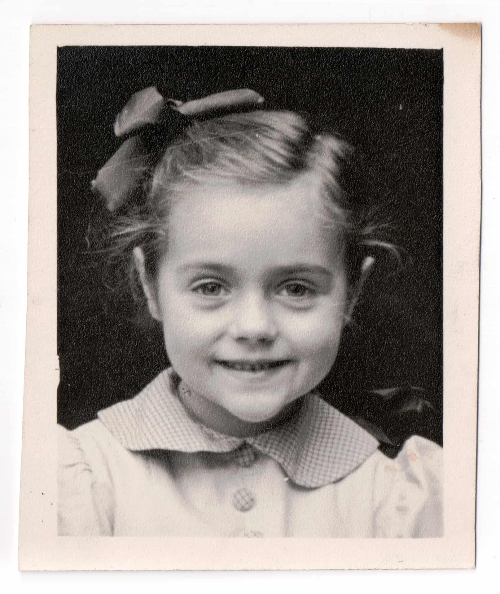 I am about five here. And the bow in the hair, Mom always did like us to have things like that. We had bows on our dresses and she didn’t like us to get them wrinkled, we always had to get them straight as we walked up the street.