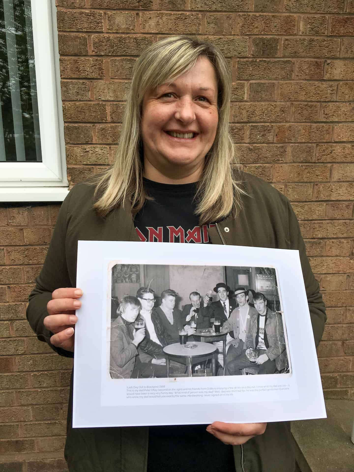 Sharon Ofley with a photo of her father and his friends from 1968