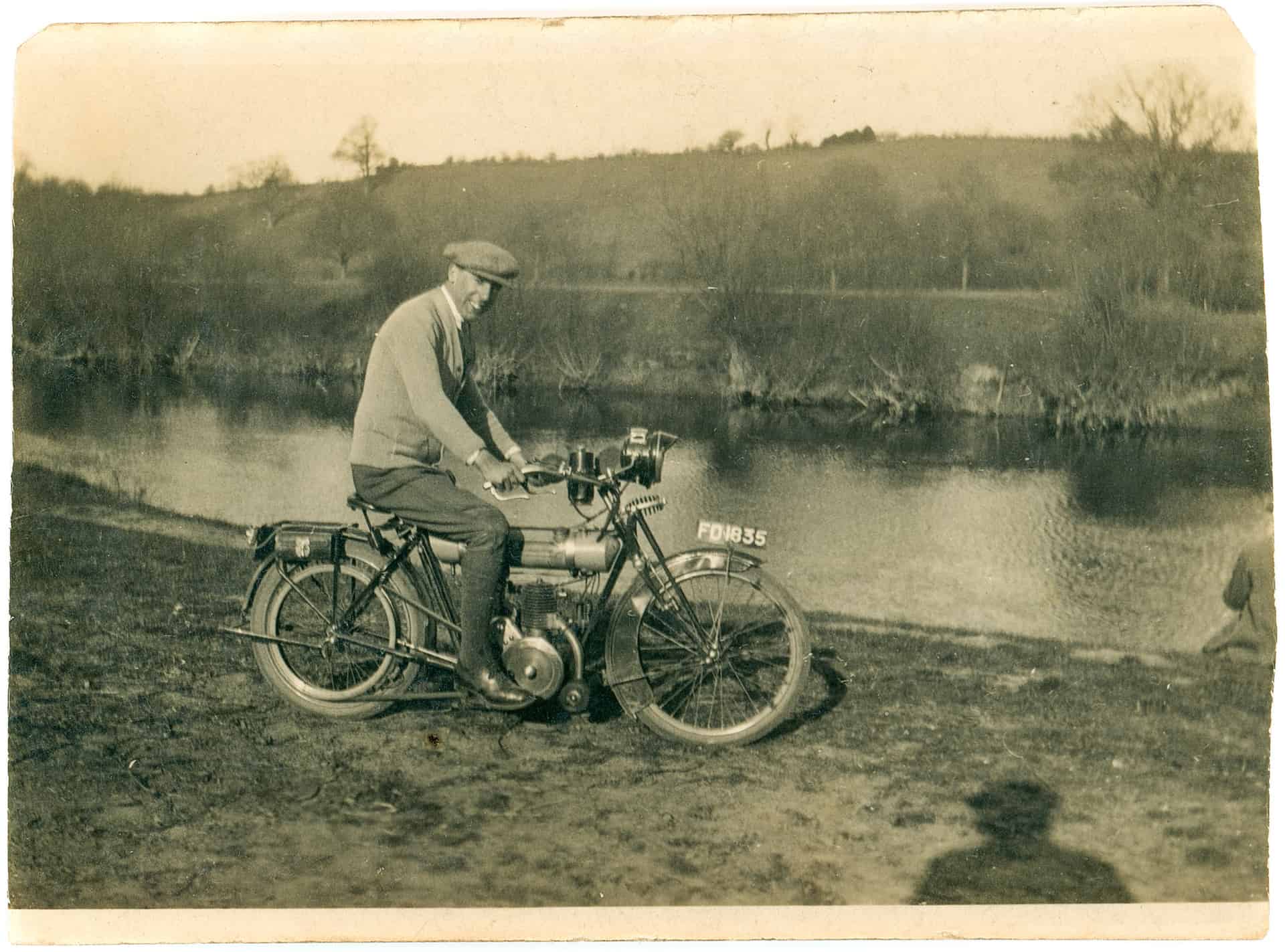 That's my dad on very much a light motorcycle, so I would think that was one of his early ones. It's barely more substantial than a push bike.There's a little engine here with a belt drive. Little tiny petrol tank. This one is from the 1920s, model unknown.